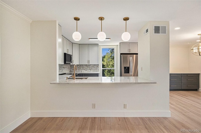 460 S Marion Pkwy Unit 604, Denver, CO 80209 - kitchen with appliances with stainless steel finishes, a peninsula, decorative backsplash, light stone counters, and light wood-type flooring