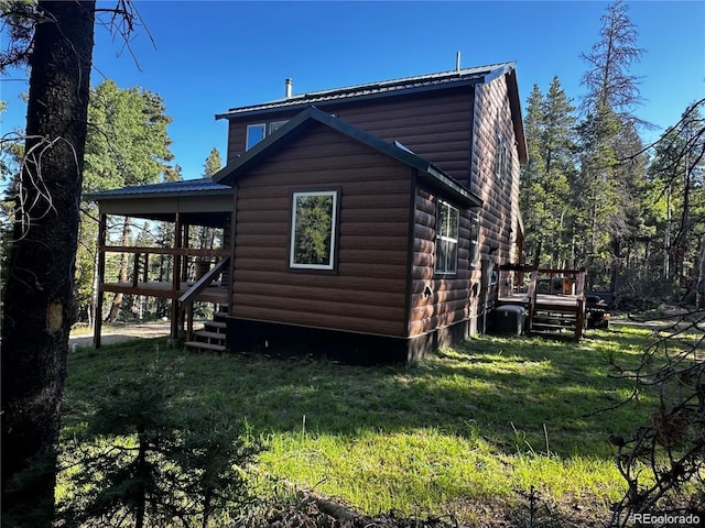 view of side of property featuring log veneer siding and a yard