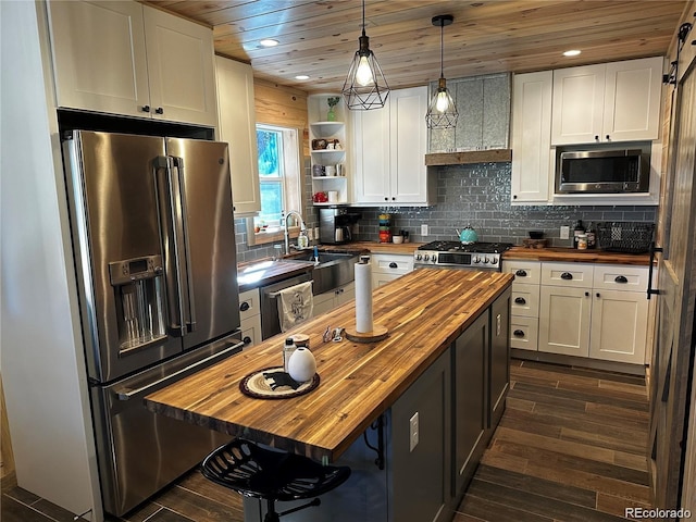 kitchen with white cabinetry, appliances with stainless steel finishes, and wooden counters