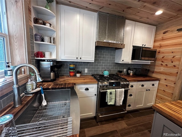 kitchen featuring tasteful backsplash, open shelves, butcher block countertops, appliances with stainless steel finishes, and a sink