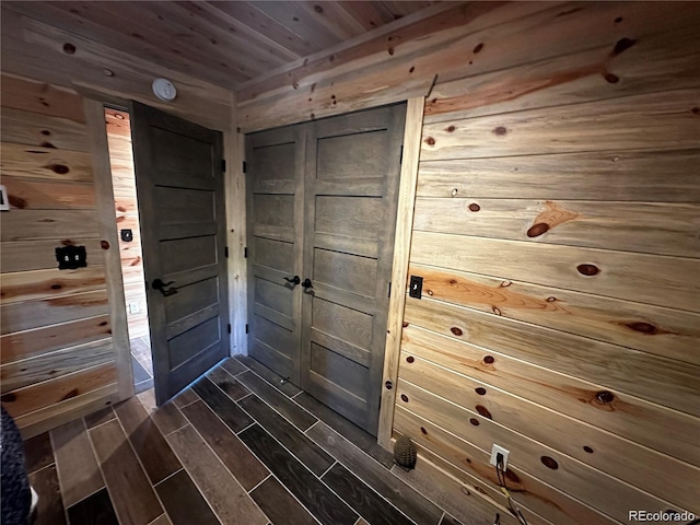 doorway featuring wood finish floors, wooden walls, and wooden ceiling