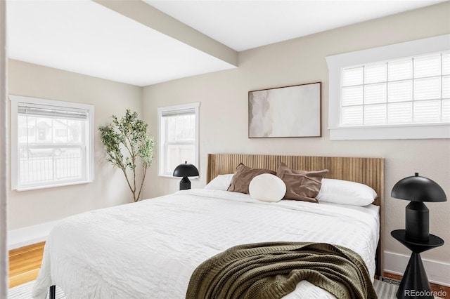 bedroom with baseboards and wood finished floors