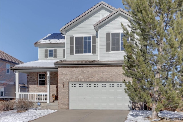 view of front of home featuring a porch, solar panels, and a garage