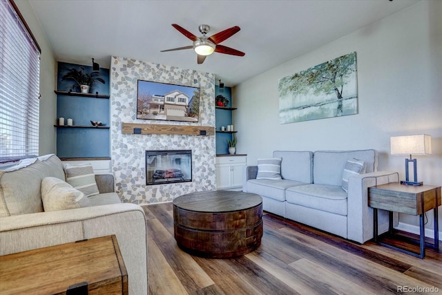 living room with ceiling fan, a fireplace, and hardwood / wood-style flooring