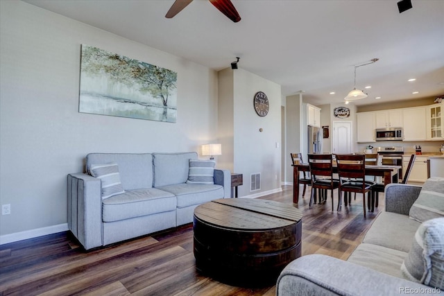 living room featuring ceiling fan and dark wood-type flooring