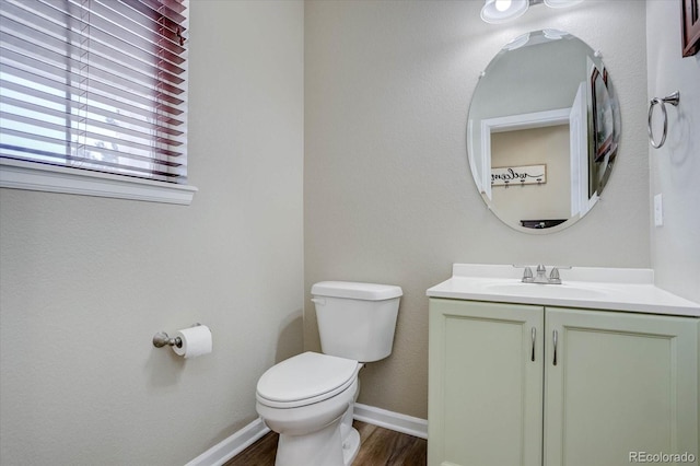 bathroom featuring toilet, vanity, and hardwood / wood-style floors