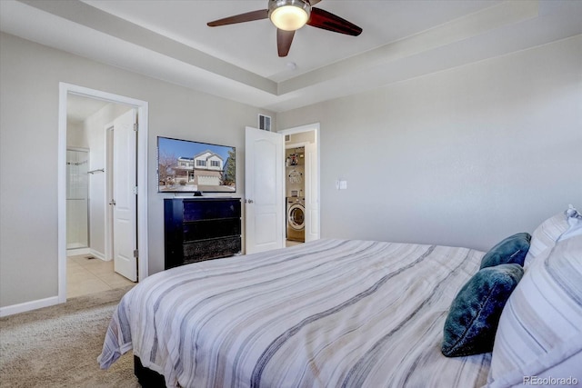 carpeted bedroom featuring ceiling fan, connected bathroom, and washer / dryer