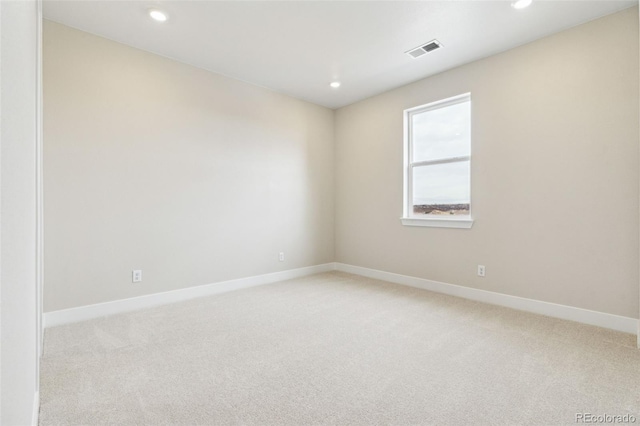 spare room featuring light carpet