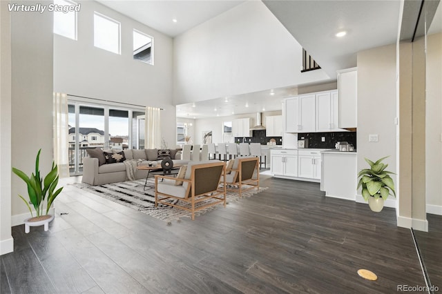 5566 Hickory Oaks Trl, Castle Rock, CO 80104 - living room featuring a towering ceiling, baseboards, dark wood-type flooring, and recessed lighting