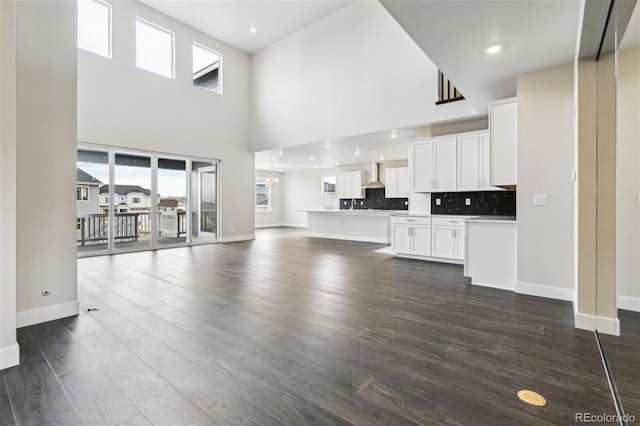 5566 Hickory Oaks Trl, Castle Rock, CO 80104 - unfurnished living room with a high ceiling, plenty of natural light, baseboards, and dark wood-style flooring
