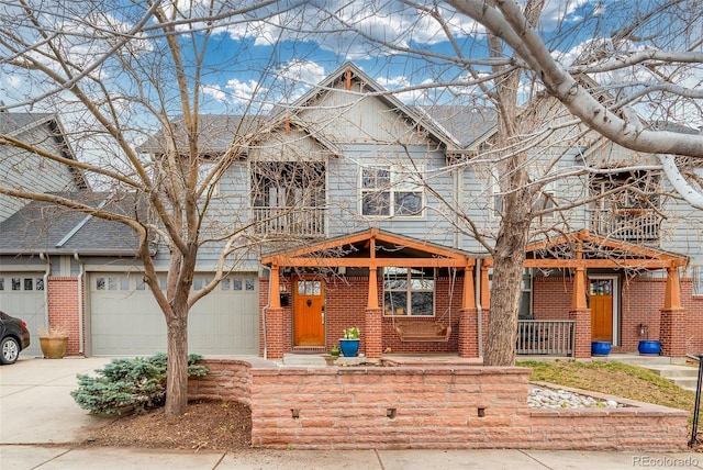 view of front of house featuring an attached garage, covered porch, brick siding, and driveway