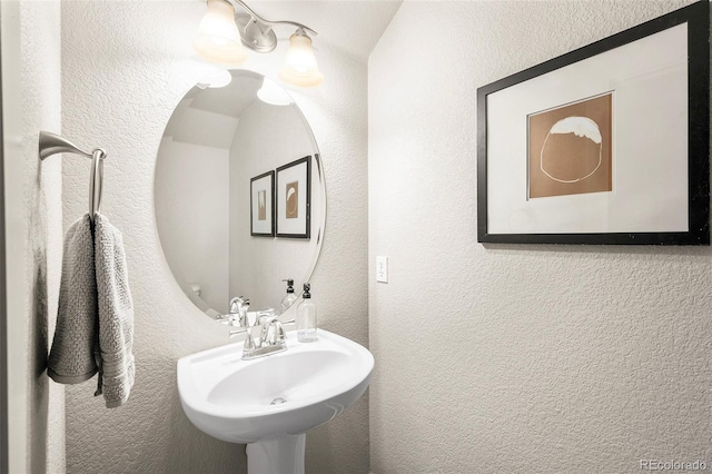 bathroom featuring a sink and a textured wall