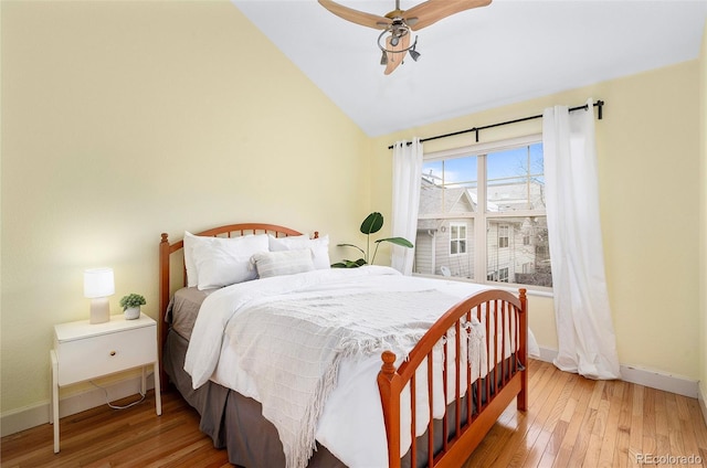 bedroom featuring ceiling fan, baseboards, lofted ceiling, and hardwood / wood-style flooring