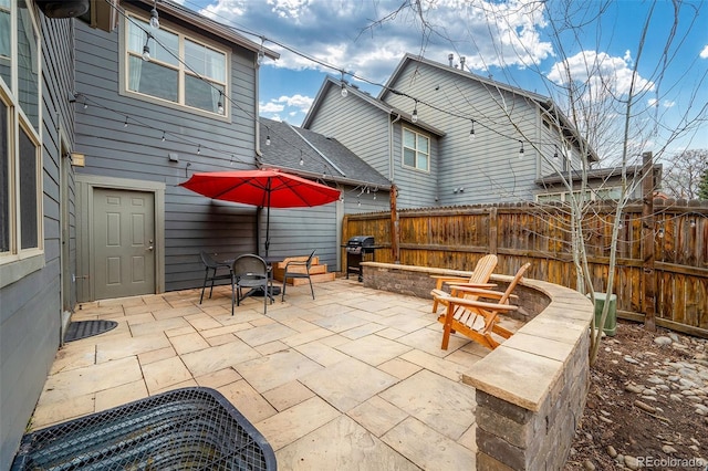 view of patio / terrace with a grill and fence