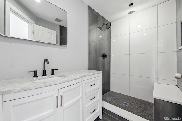 bathroom with vanity and tiled shower