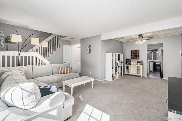 carpeted living room featuring a textured ceiling and ceiling fan