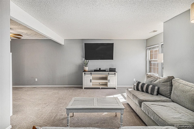 carpeted living room with ceiling fan, beam ceiling, and a textured ceiling