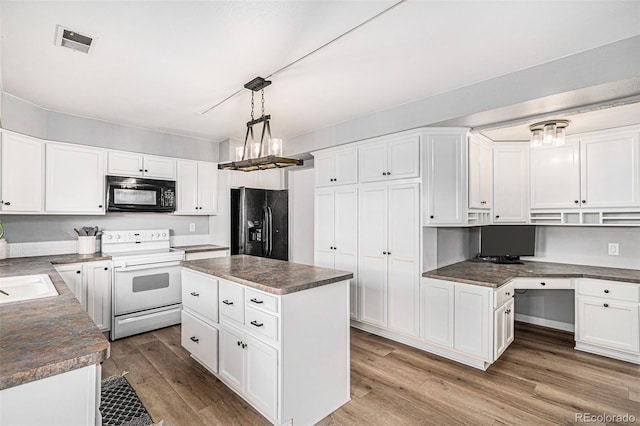 kitchen featuring a kitchen island, black appliances, decorative light fixtures, and light wood-type flooring