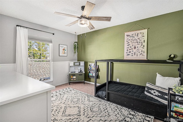 bedroom with carpet flooring, a textured ceiling, and ceiling fan