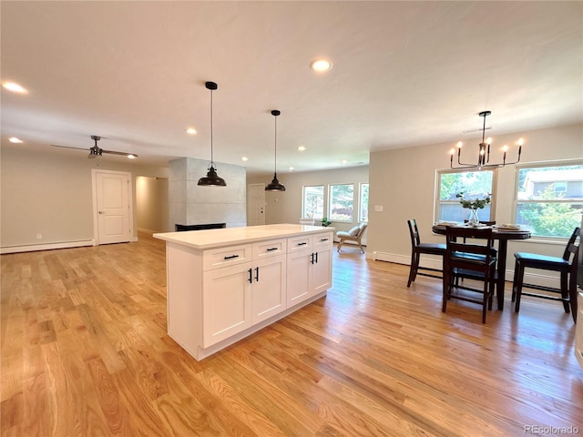 9451 E Evans Pl, Denver, CO 80231 - kitchen featuring baseboard heating, light wood finished floors, recessed lighting, a center island, and white cabinetry
