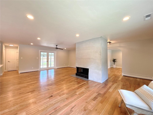 9451 E Evans Pl, Denver, CO 80231 - unfurnished living room featuring a baseboard radiator, arched walkways, a ceiling fan, recessed lighting, and light wood-type flooring