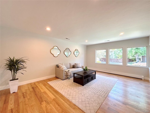 9451 E Evans Pl, Denver, CO 80231 - living room featuring a baseboard radiator, light wood-type flooring, and recessed lighting