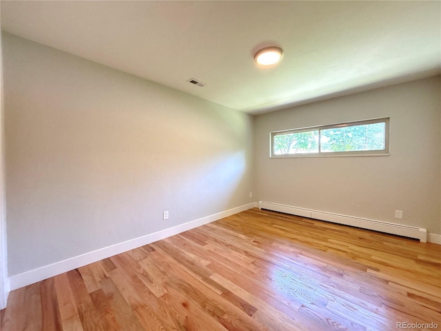 9451 E Evans Pl, Denver, CO 80231 - spare room with a baseboard heating unit and light wood-style floors