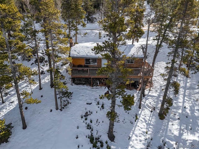 snow covered rear of property with a wooden deck