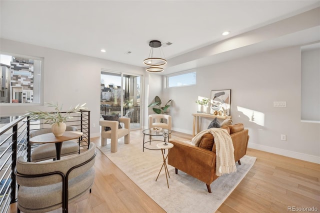 living area featuring recessed lighting, light wood-type flooring, and baseboards