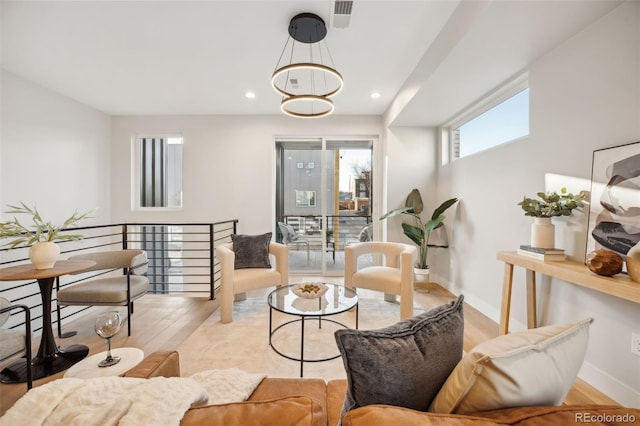 living area with baseboards, visible vents, wood finished floors, a notable chandelier, and recessed lighting