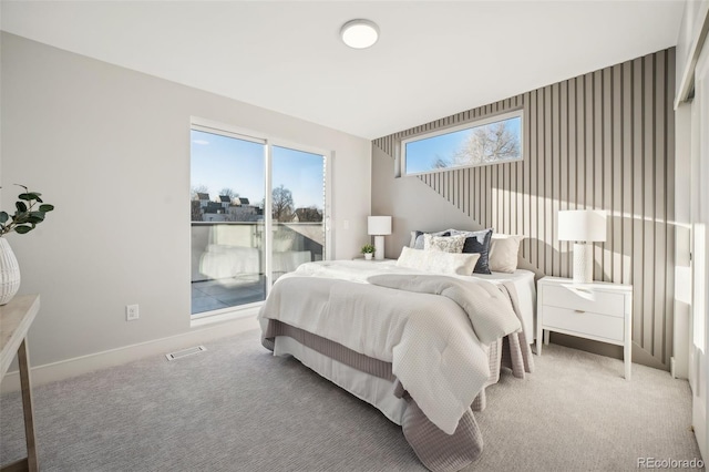 carpeted bedroom featuring access to exterior, visible vents, and baseboards