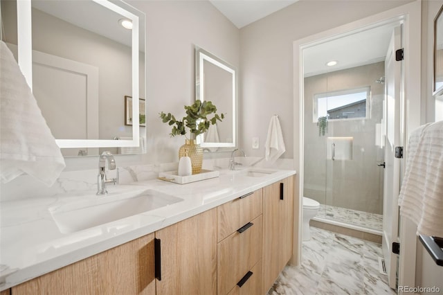 full bathroom with marble finish floor, double vanity, a stall shower, and a sink