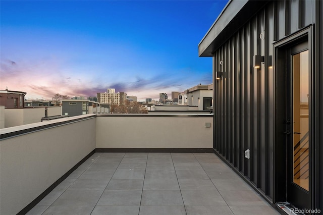 balcony at dusk featuring a city view