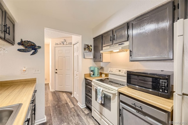 kitchen with sink, wood counters, dark wood-type flooring, and white appliances