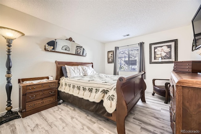 bedroom featuring light hardwood / wood-style flooring and a textured ceiling