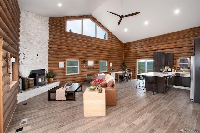 57 Overlook Ct, Idaho Springs, CO 80452 - living room featuring high vaulted ceiling, ceiling fan, rustic walls, light wood-style floors, and plenty of natural light