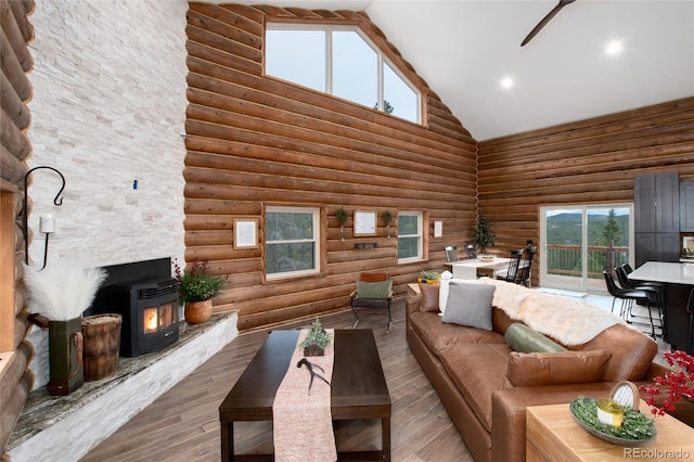 57 Overlook Ct, Idaho Springs, CO 80452 - living room with high vaulted ceiling, wood finished floors, log walls, ceiling fan, and a wood stove