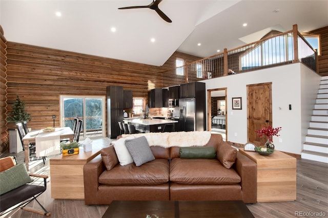 57 Overlook Ct, Idaho Springs, CO 80452 - living room with high vaulted ceiling, light wood-style floors, stairs, rustic walls, and a ceiling fan
