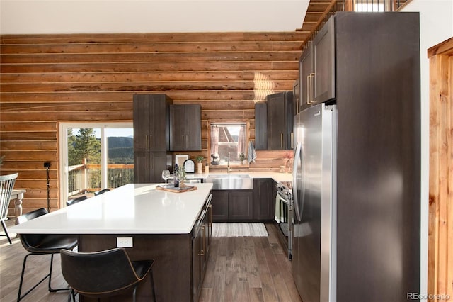 57 Overlook Ct, Idaho Springs, CO 80452 - kitchen featuring appliances with stainless steel finishes, dark wood finished floors, plenty of natural light, a center island, and log walls