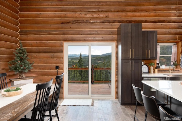 57 Overlook Ct, Idaho Springs, CO 80452 - dining area with a mountain view, light wood-style flooring, rustic walls, and healthy amount of natural light