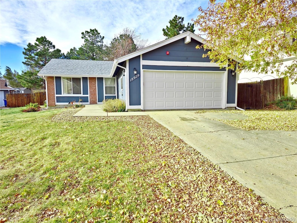 ranch-style house featuring a front yard and a garage