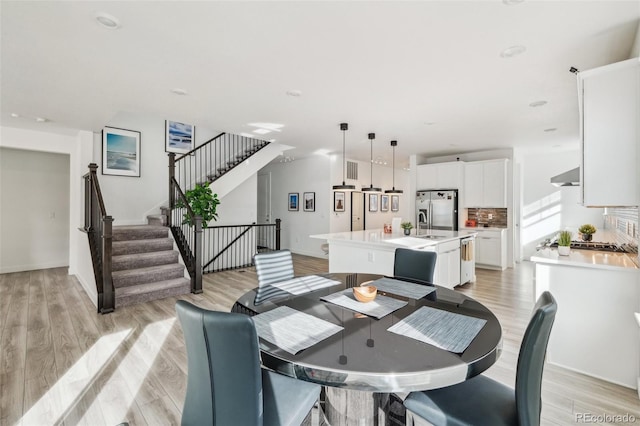 dining room with sink and light hardwood / wood-style flooring