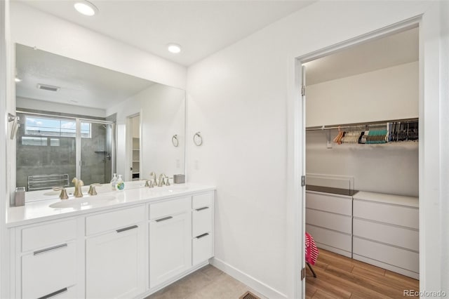 bathroom featuring vanity, hardwood / wood-style floors, and a shower with door