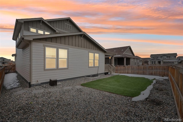 back house at dusk with a yard