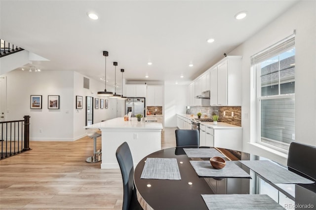 dining space featuring sink and light hardwood / wood-style floors