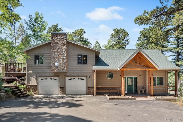 rustic home with an attached garage, a shingled roof, stairs, driveway, and a chimney