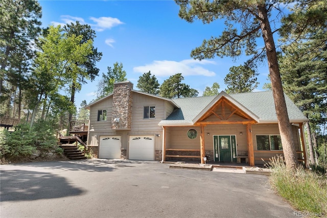 view of front of house with a shingled roof, stone siding, driveway, and an attached garage