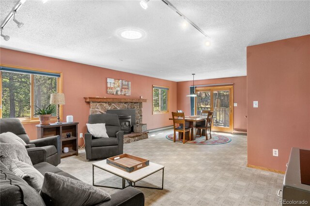 living room with a wealth of natural light, a baseboard radiator, and light carpet