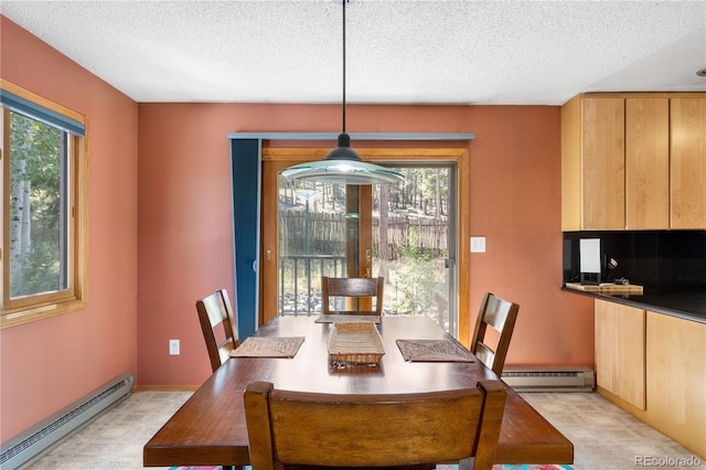 dining space with a baseboard heating unit, a textured ceiling, a baseboard radiator, and a wealth of natural light