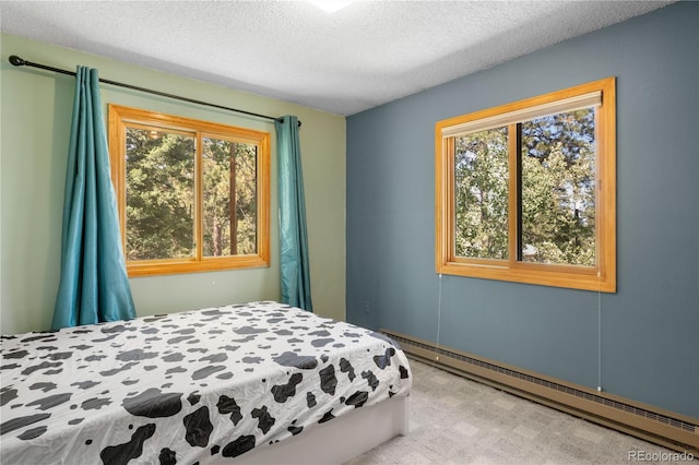 bedroom with a textured ceiling and baseboard heating